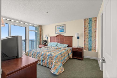 um quarto de hotel com uma cama e uma televisão em Holiday 1111 - Charming oceanfront condo with beachfront panoramic views, Pools em Myrtle Beach