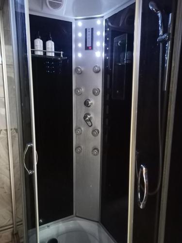 a shower with a glass door in a bathroom at Площадь in Qyzylorda