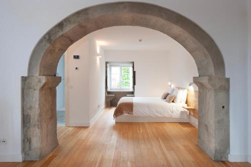 a bedroom with an archway with a bed in it at AngrA + in Angra do Heroísmo
