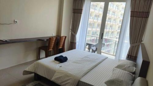 a bedroom with a bed with a blue hat on it at SleepRest @ NTC in Nagoya