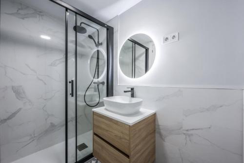 a white bathroom with a sink and a shower at atico reformado con terraza en lavapies in Madrid