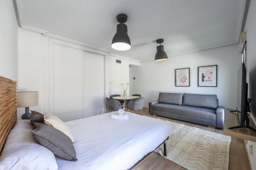 a bedroom with a large bed and a couch at atico reformado con terraza en lavapies in Madrid