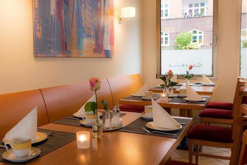 eine Reihe von Tischen in einem Restaurant mit Kerzen darauf in der Unterkunft Hotel Cristobal in Hamburg