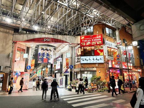 a group of people crossing a street in a city at Koenji loft apartment/Shinjuku&Kichijoji/JR in Tokyo