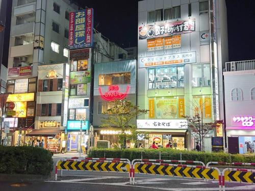a city street at night with many signs at Koenji loft apartment/Shinjuku&Kichijoji/JR in Tokyo
