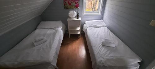 Duas camas num pequeno quarto com uma janela em Jøssingfjord Apartments em Sokndal