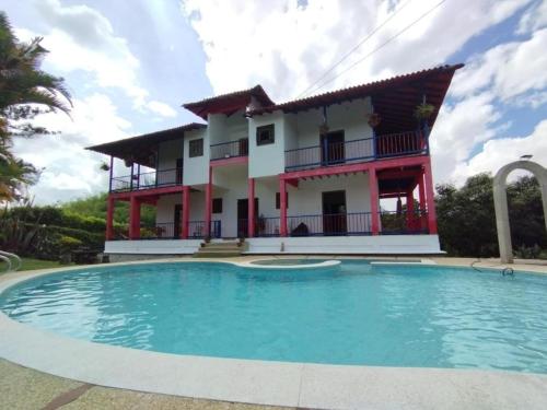 une villa avec une piscine en face d'une maison dans l'établissement Finca Hotel Calle Jardin, à La Tebaida