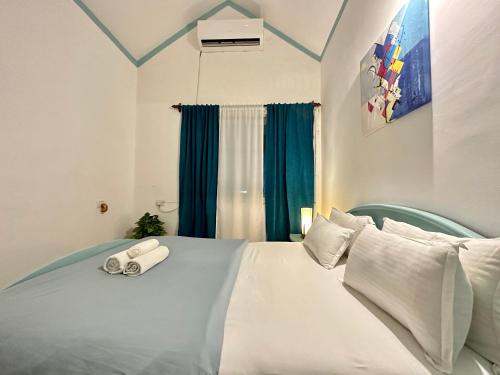 een wit bed met twee opgerolde handdoeken erop bij Villa By The Beach Goa in Benaulim