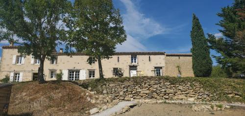 een groot huis met een stenen muur ervoor bij Bessire Chambres & table d'hôtes 
