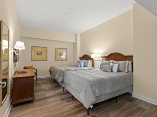 a large bedroom with two beds and a table at Family friendly ocean view condo, beachfront building, pool and wifi included, M in Myrtle Beach