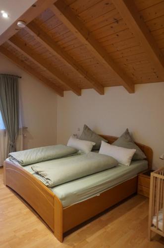 a large bed in a room with wooden ceilings at Ferienwohnung im Brechstubenweg in Kiefersfelden