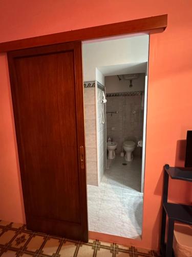 une porte menant à une salle de bains pourvue de toilettes. dans l'établissement Corte De Ritis, à Giovinazzo