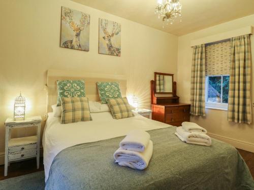 a bedroom with a bed with two towels on it at Knoll Cottage in Bakewell