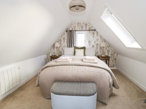 a bedroom with a large bed in a attic at Beech Cottage in Lochs