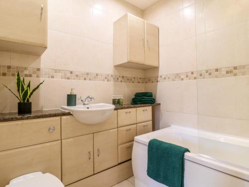 ein Badezimmer mit einem Waschbecken, einer Badewanne und einem WC in der Unterkunft 2 Dove Cottage in Uttoxeter