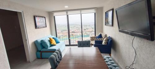uma sala de estar com uma mesa e uma televisão de ecrã plano em Beautiful and modern apartment em Tonalá