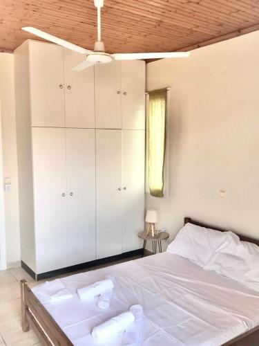 a bedroom with a large bed with white cabinets at Les Oliviers Villa with Sea view on Petani Beach in Vovikes