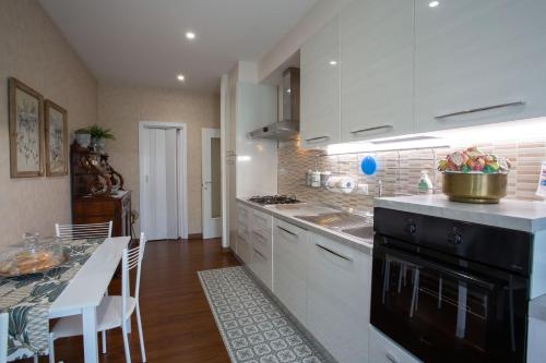 a kitchen with white cabinets and a black stove top oven at Dimora Giulia in Campobasso
