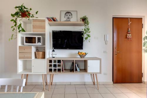 una sala de estar con TV y un centro de entretenimiento blanco en A casa di Anna en San Miniato