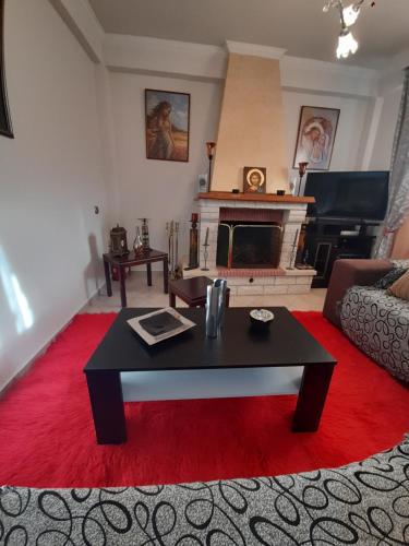a living room with a coffee table and a fireplace at Villa of byron in Kastrákion