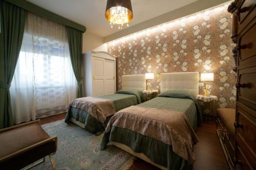 カンポバッソにあるDimora Giuliaのベッドルーム1室(ベッド2台付)、花の壁が備わります。