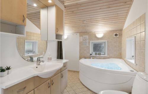 a bathroom with a tub and a sink at Beautiful Home In lbk With 3 Bedrooms And Wifi in Ålbæk