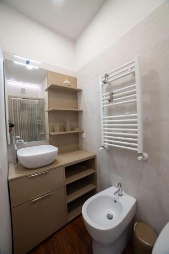 a bathroom with a sink and a toilet and a mirror at Dimora Giulia in Campobasso