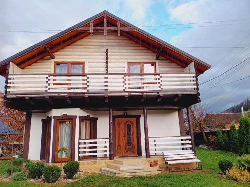 a small white house with a red door at Villa Zgarda1 in Mykulychyn