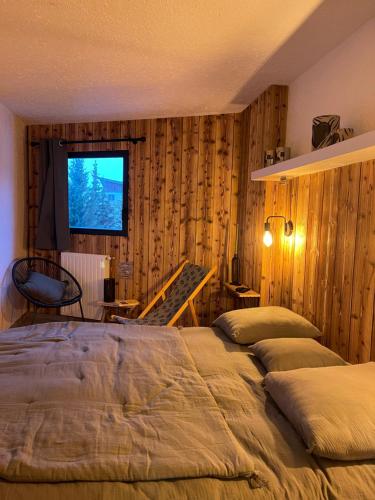 1 dormitorio con 2 camas y TV en la pared en Le repère de Bianca, le premier de cordée en Montgenèvre