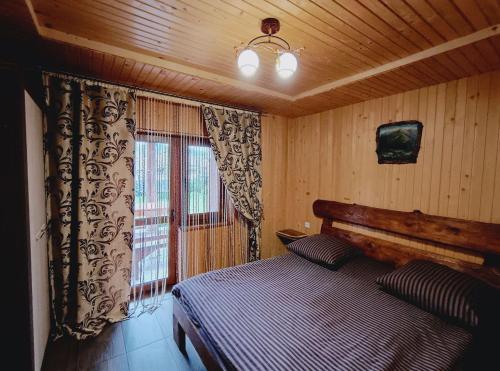 a bedroom with a bed and a tv and a window at Villa Zgarda1 in Mykulychyn