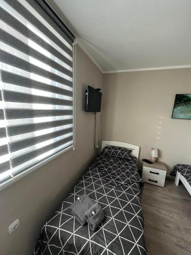 a bedroom with a bed and a large window at Apartman Petrov in Donji Milanovac