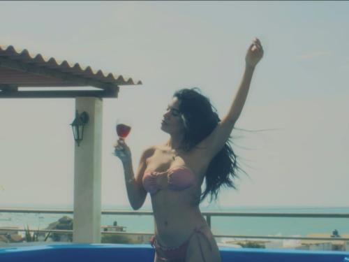 a woman holding a glass of wine at a pool at Casa Norte North Beach in Los Órganos