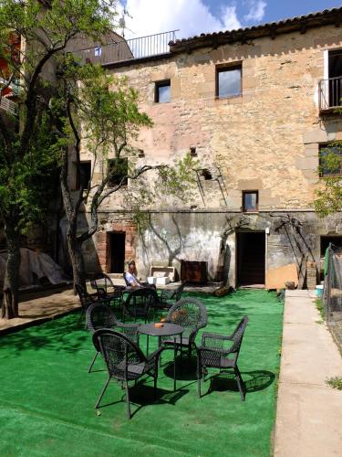 a patio with tables and chairs on a green lawn at El Albergue de Sigüenza in Sigüenza
