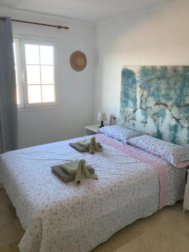 een slaapkamer met een bed met handdoeken erop bij Las Arenas caleta de fuste in Caleta De Fuste