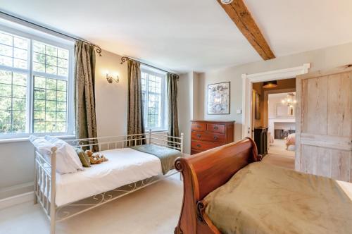 een slaapkamer met een bed, een bank en ramen bij Perry Farm by Bloom Stays in Canterbury