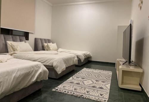 a room with two beds and a flat screen tv at شقه عائليه بمدخل خاص in Riyadh