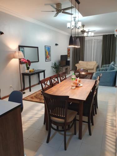 een eetkamer en een woonkamer met een tafel en stoelen bij Sri Lagenda Apartment Langkawi in Kuah