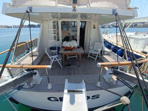 a boat with a table and chairs on the deck at Ciudad y playa desde un barco. in Valencia