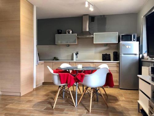 La cuisine est équipée d'une table, de chaises et d'un réfrigérateur. dans l'établissement Bike - Apartament Ustroń Orzechowa 66, à Ustroń