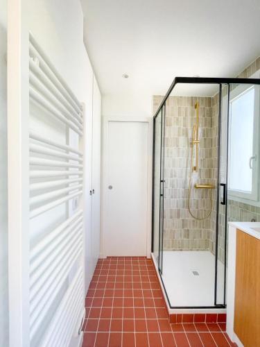 La salle de bains est pourvue d'une douche et de carrelage. dans l'établissement Petit Vallon - Wifi - Parking - 2 Chbres - Clim, à Cassis