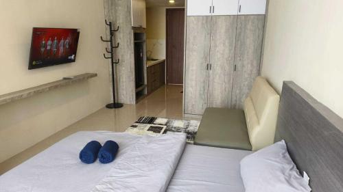 a bedroom with a bed with blue shoes on it at SleepRest @ NTC in Nagoya