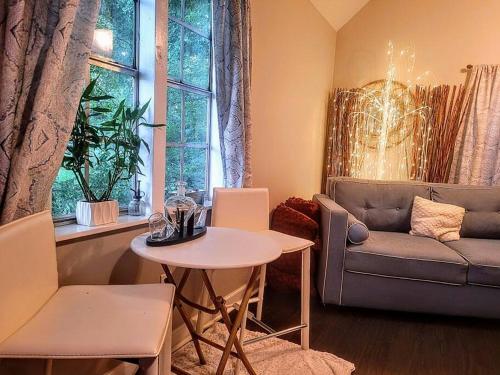 a living room with a table and a couch at Cozy Delightful Private Studio near Rhodes College, Shuttle, & Vehicle Rental in Memphis