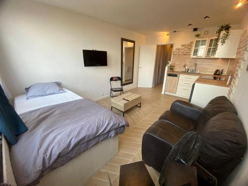 Cet appartement comprend une chambre avec un lit et un canapé ainsi qu'une cuisine. dans l'établissement Full Loft in PARIS - 2 single beds for 2 - Chinatown, à Paris