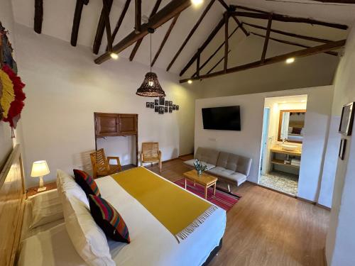 ein Schlafzimmer mit einem großen Bett und ein Wohnzimmer in der Unterkunft CASA CRISTOBAL Siete Cuartones CASONA COLONIAL in Cusco