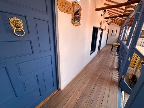 a blue door in a hallway with a wooden floor at CASA CRISTOBAL Siete Cuartones in Cusco