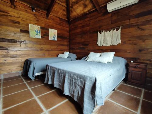 2 camas en una habitación con paredes de madera en El Cardon - Casa de Campo en Coronel Moldes