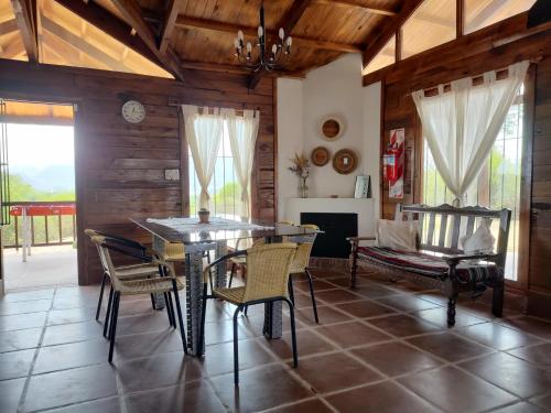 a dining room with a table and chairs and a couch at El Cardon - Casa de Campo in Coronel Moldes