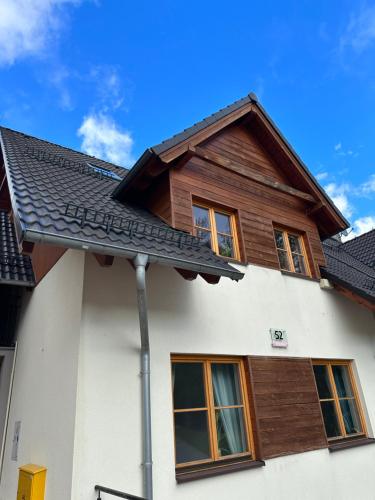 a house with a wooden roof at Śnieżkowe Love - dwupoziomowy apartament z garażem in Karpacz