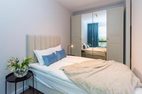 a bedroom with a large bed and a mirror at Scala Rentyear Apartments in Gdańsk