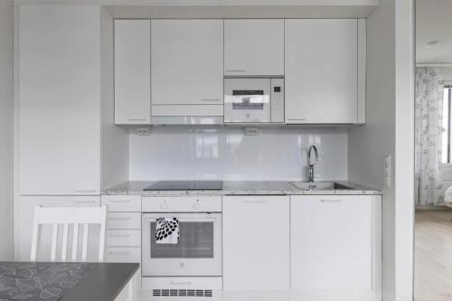 クオピオにあるBeautiful Modern City Apartmentの白いキッチン(白いキャビネット、シンク付)